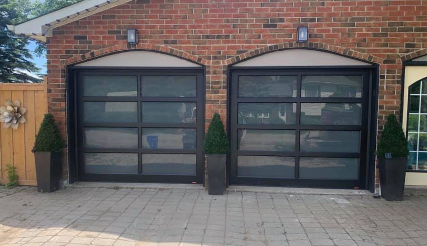 Two large garage doors featuring sleek black glass, providing a modern and elegant appearance to the exterior.