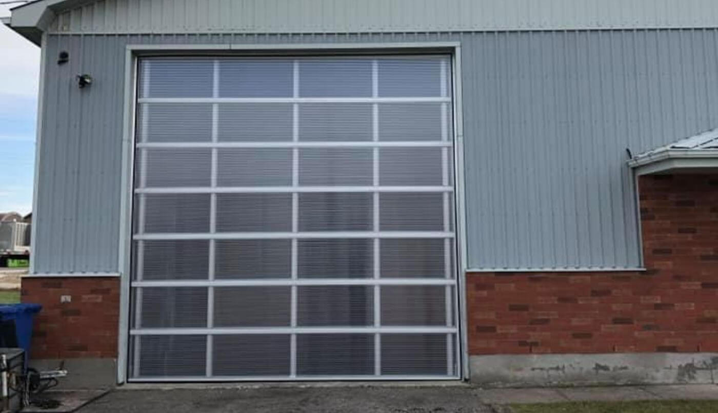 A large garage door featuring windows, providing a view of the exterior surroundings.