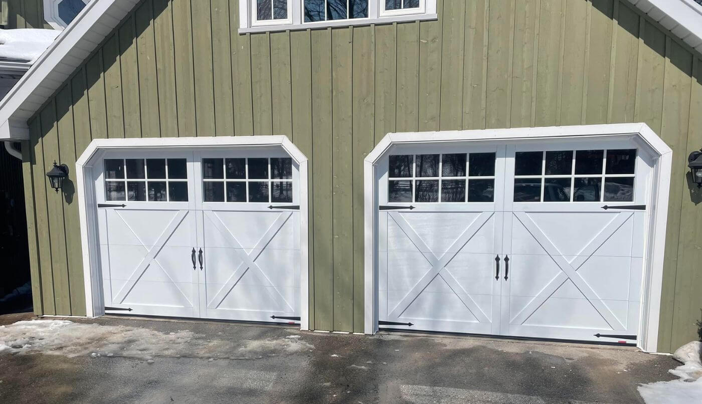 Two garage doors featuring white Carriage house style garage doors, enhancing the exterior aesthetic of a residential property.